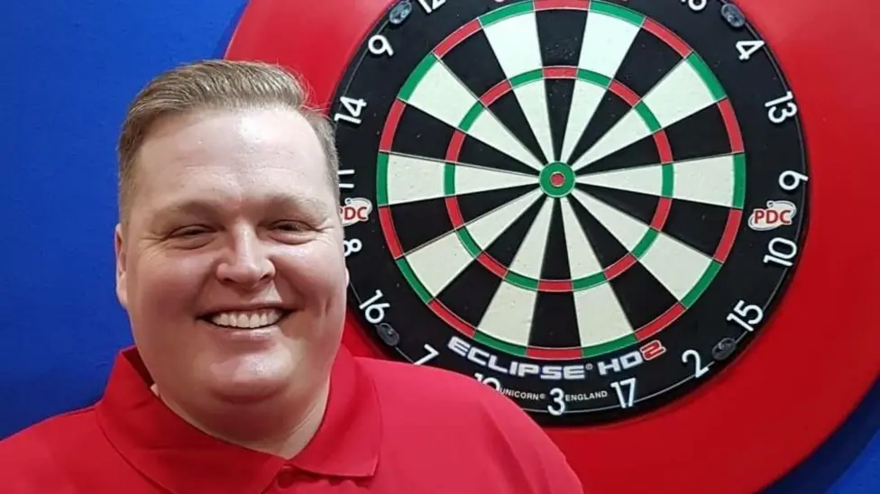 Simon alongside dart board