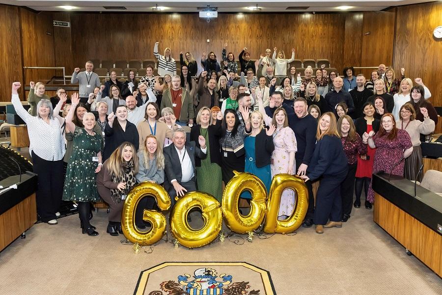 Photo of staff behind some gold balloons with 'good' on them